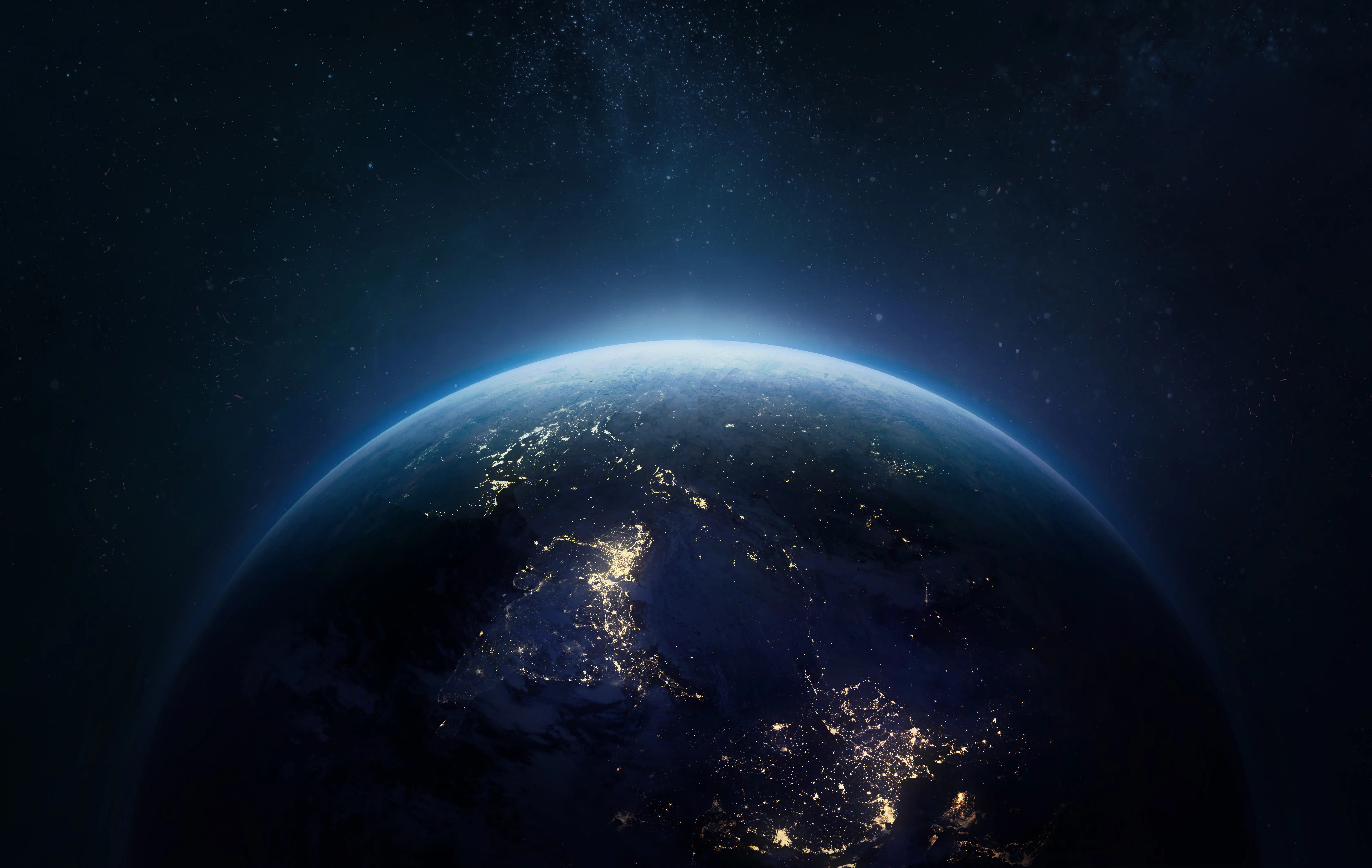 Vista nocturna de la Tierra desde el espacio exterior con luces de ciudades en la superficie del planeta